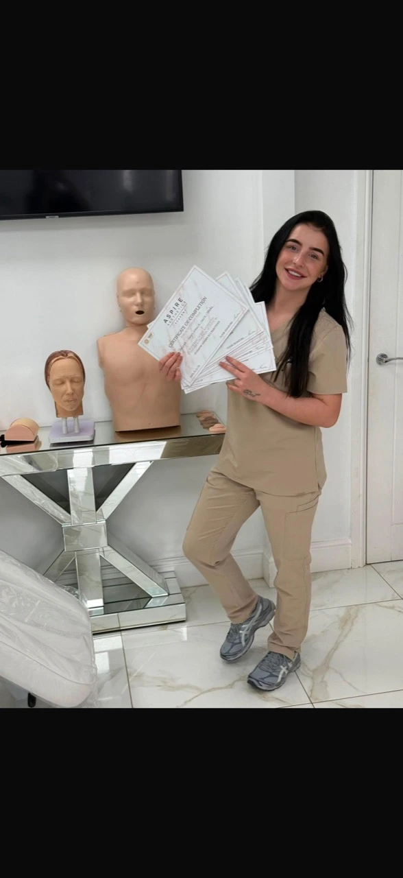 Shania smiling and holding her aesthetics training certificates